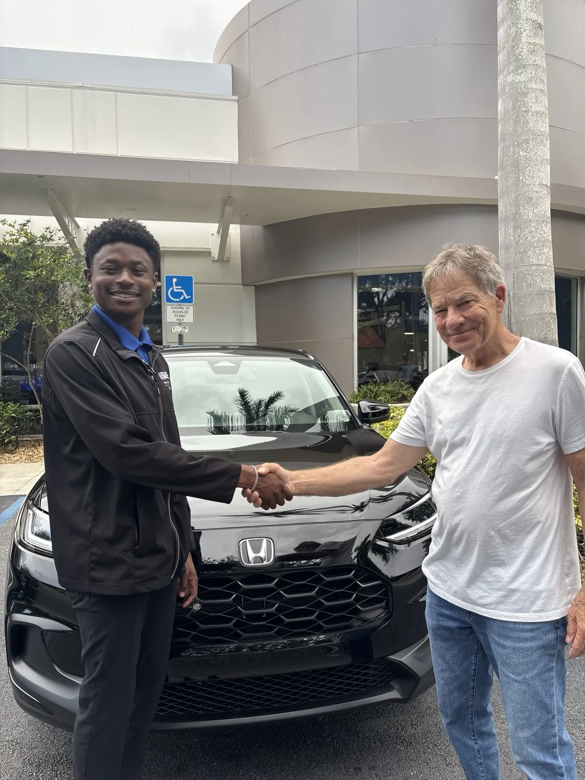 Greg with a customer and their vehicle
