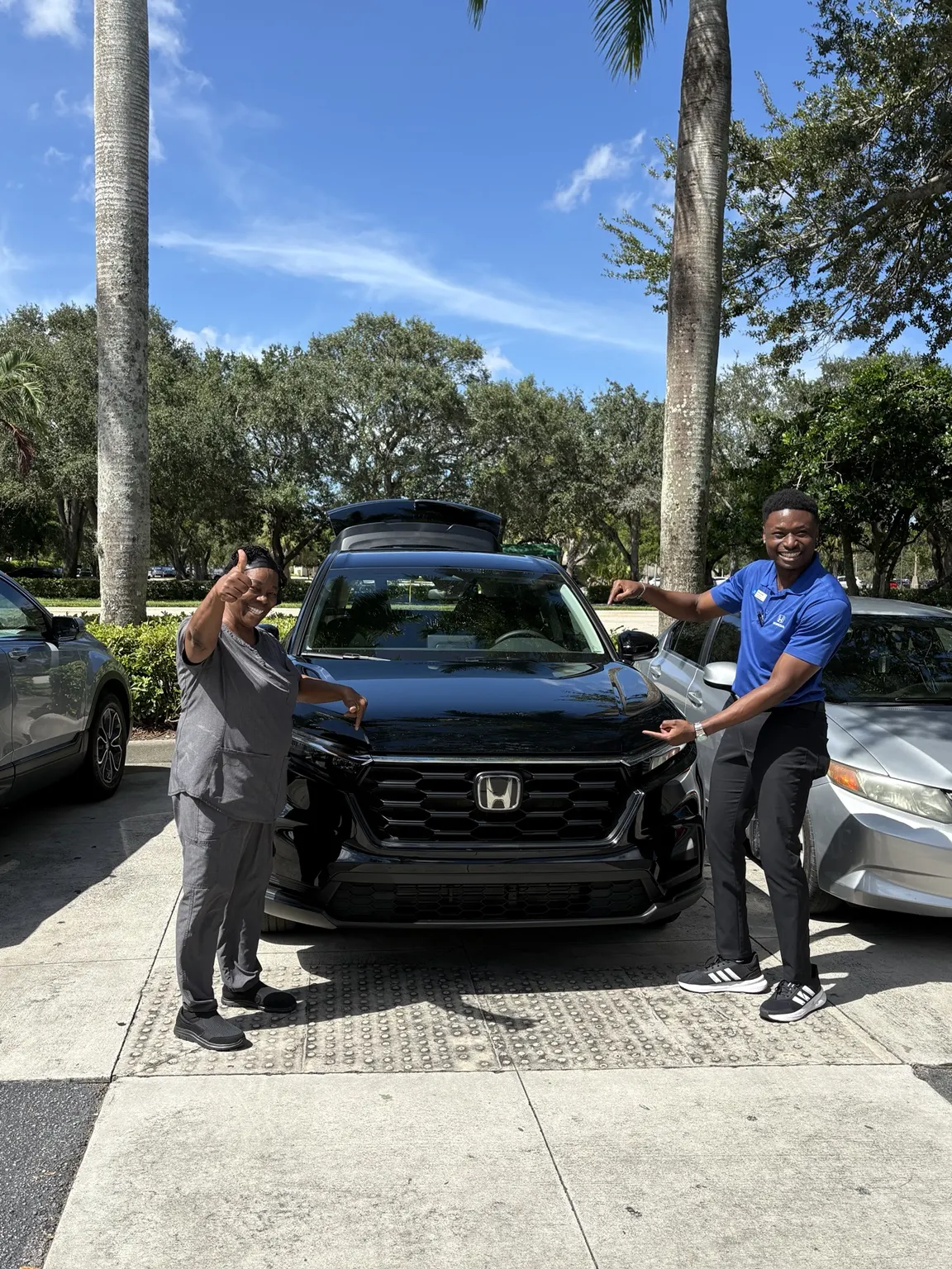 Greg with a customer and their vehicle